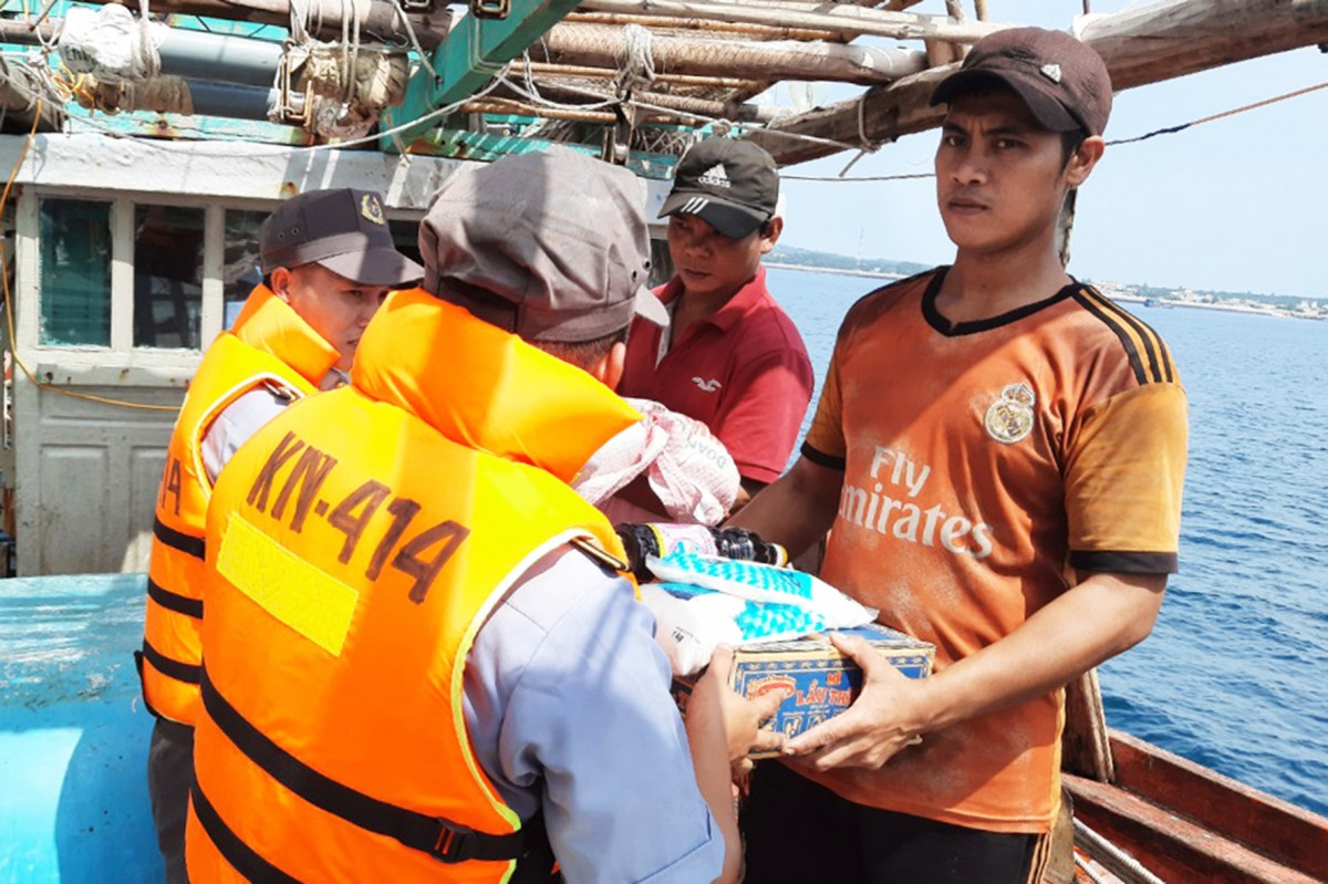 Nhân viên tàu KN 414 cung cấp thực phẩm cho ngư dân tàu BĐ 97865 TS.
