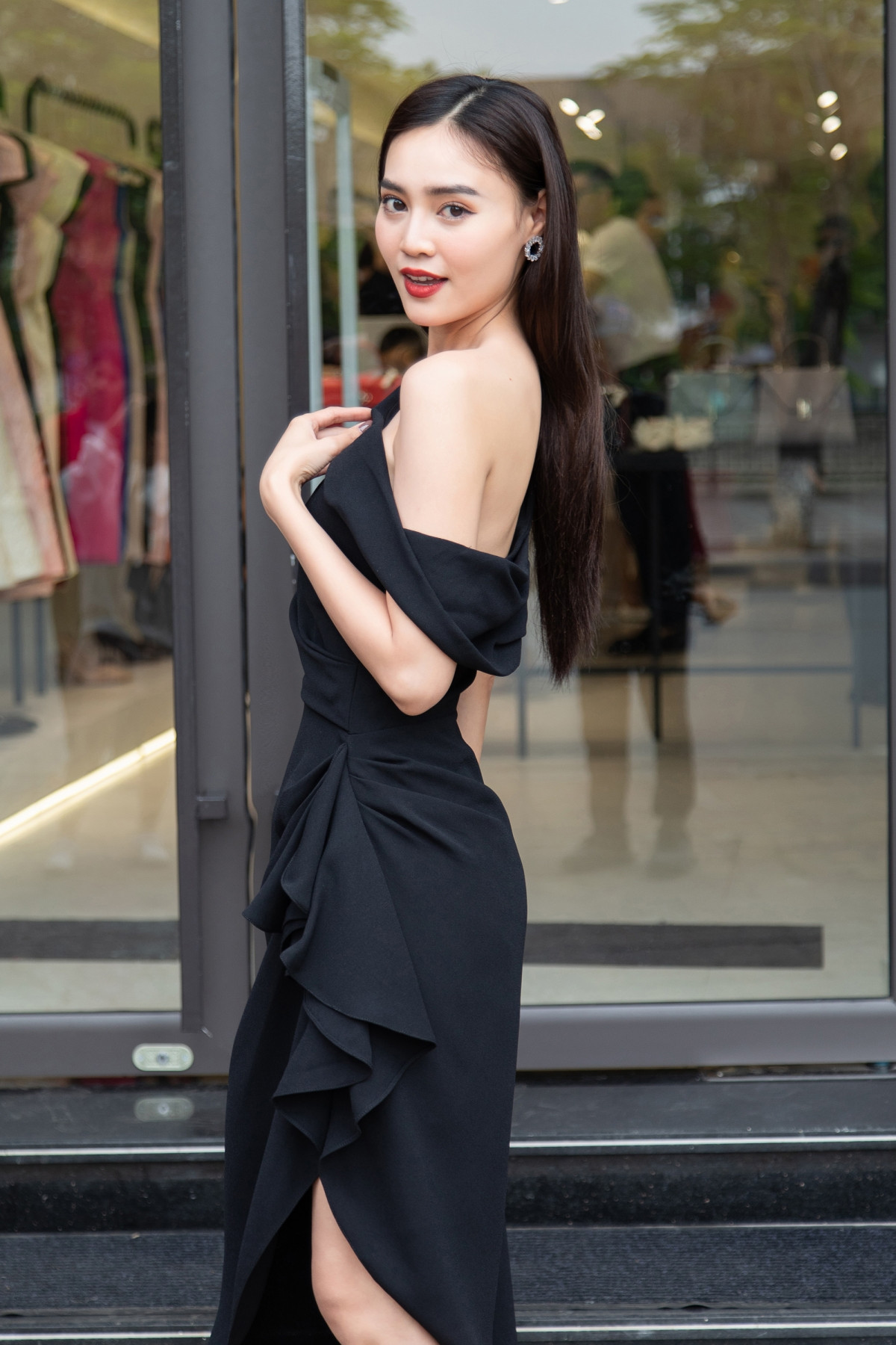 Nữ diễn viên diện chiếc váy màu đen với những đường gấp nếp độc đáo để tạo nên phom dáng bất đối xứng của trang phục. Đó cũng là thế mạnh, màu sắc riêng của NTK Đỗ Mạnh Cường.