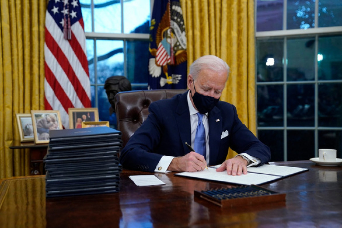 Tổng thống Biden ký sắc lệnh hành pháp trong phòng Bầu Dục ngay sau lễ nhậm chức. Ảnh: AP