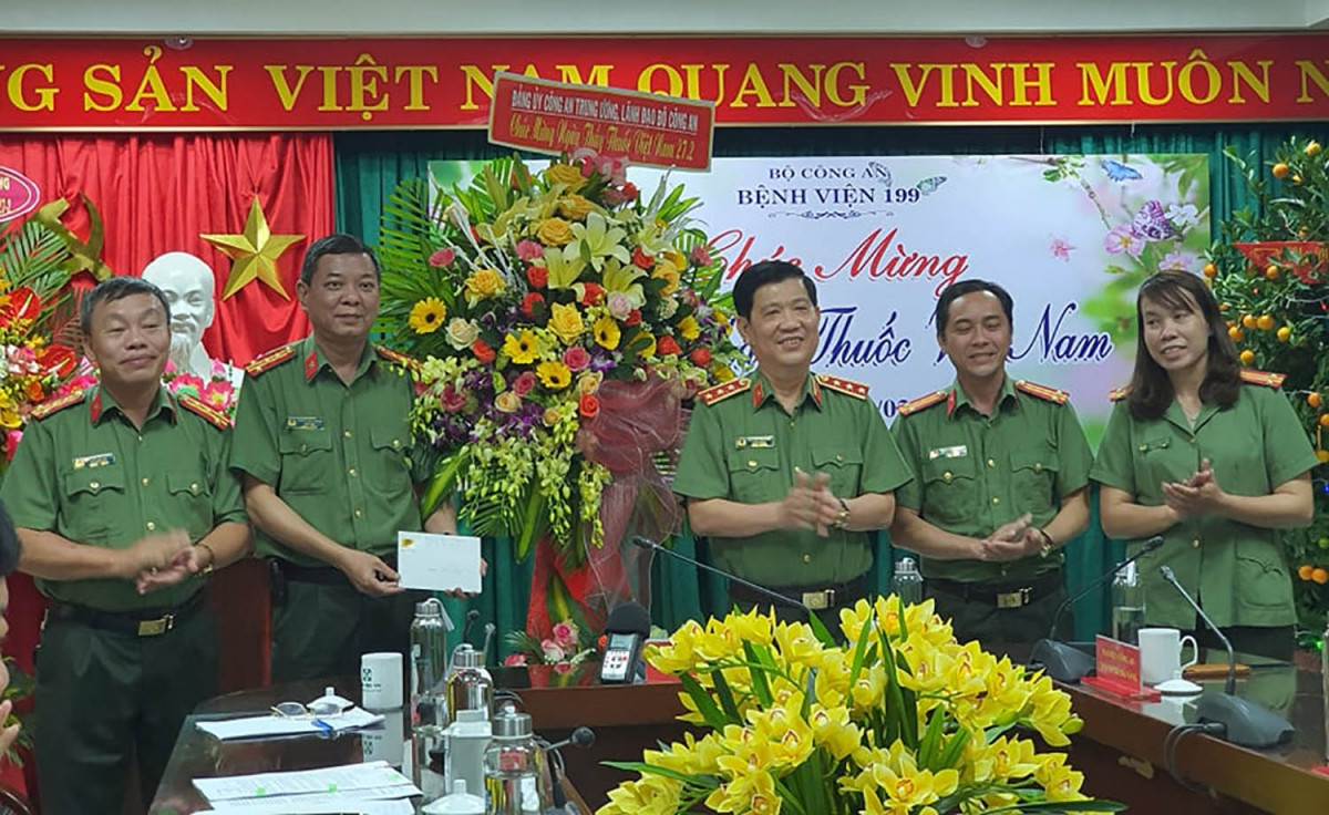 Thứ trưởng Nguyễn Văn Sơn (đứng giữa bên phải) tặng hoa cho cán bộ Bệnh viện 199.