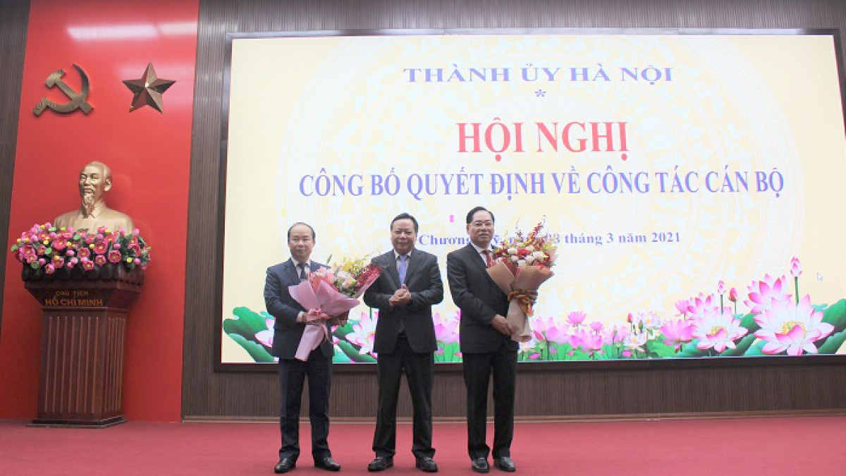 Phó Bí thư Thành ủy Nguyễn Văn Phong trao Quyết định, tặng hoa chúc mừng 2 cán bộ (Ảnh: Cổng TTĐT TP Hà Nội)