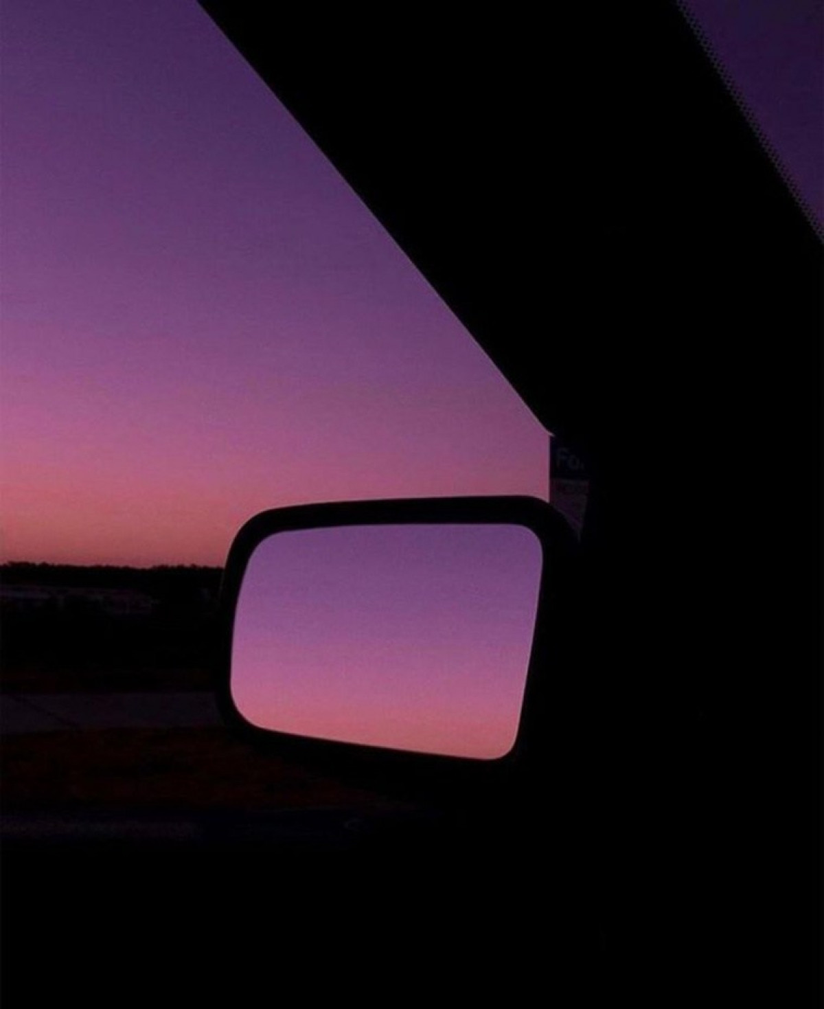 Bầu trời như hòa cùng một sắc giữa thế giới thực và hình ảnh phản chiếu trên gương ô tô.