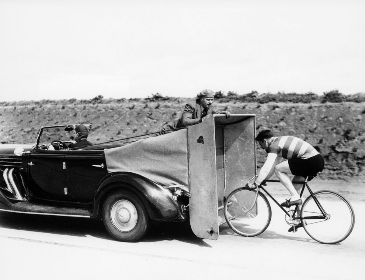 Trong bức ảnh được chụp vào năm 1935 này, một người đàn ông đang luyện tập đạp xe phía sau một chiếc ô tô cùng chiếc bạt gió. 