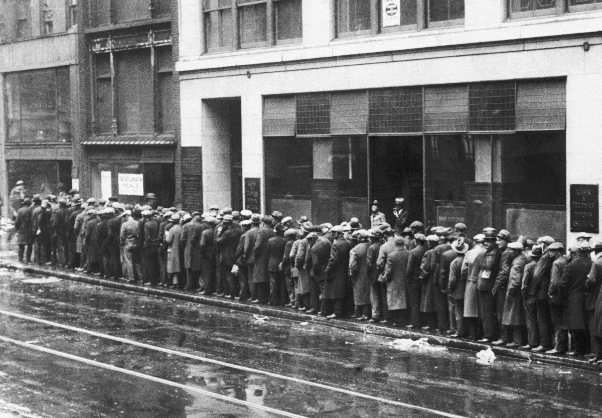 Năm 1930. Những người đàn ông thất nghiệp xếp hàng chờ lấy bánh mì và nhu yếu phẩm trong cuộc Đại Suy Thoái. Vào năm 1932, cứ 3 người New York thì 1 người thất nghiệp, và khoảng 1,6 triệu người sống nhờ vào trợ cấp chính phủ.