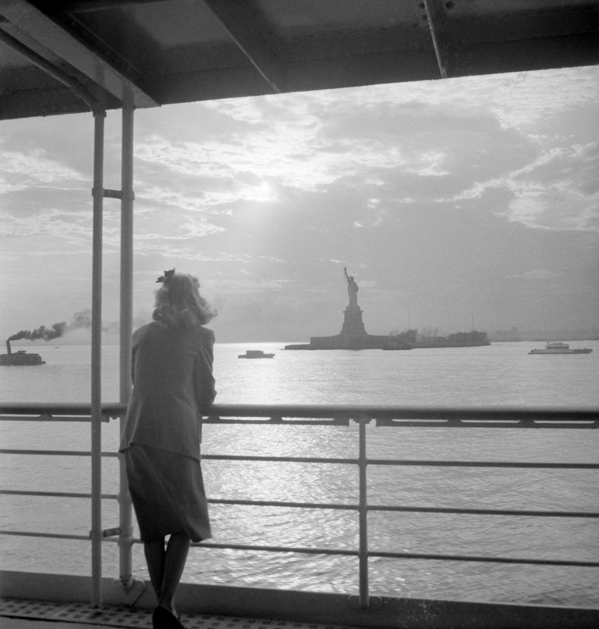 Một người phụ nữ nhìn ra Tượng Nữ thần Tự do từ boong của một chiếc phà vào đầu những năm 1900. Bức tượng do Pháp làm và trao tặng cho Mỹ nhằm vinh danh 100 năm độc lập của Mỹ.