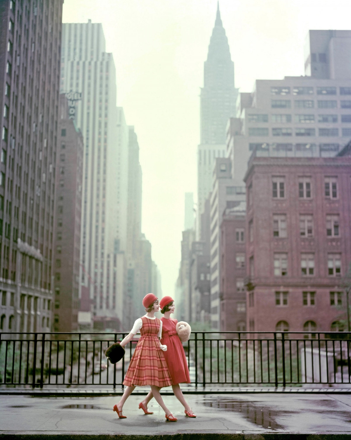 Năm 1958. Hai người mẫu mặc áo choàng lông, mũ nồi nhung và váy ngang eo đi bộ qua Cầu Tudor City trong buổi chụp hình cho tạp chí Vogue.