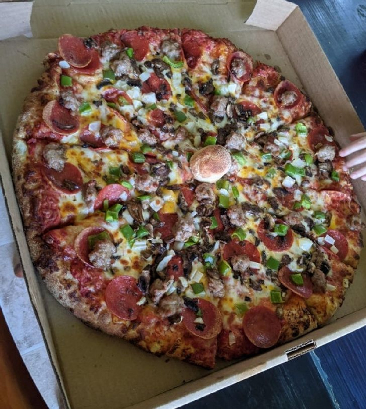 Cửa hàng bánh pizza đã cẩn thận thêm một mẩu bánh mì ở giữa chiếc pizza để nắp bìa trên của hộp đựng bánh không còn bị dính vào phần nhân bánh. 