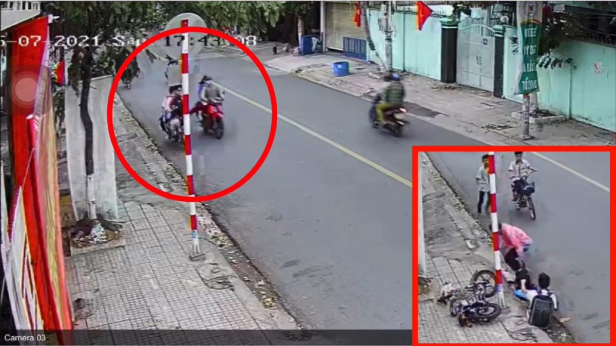 Hình ảnh 2 học sinh bị người đi xe máy đạp ngã xuống đường được cắt từ video.