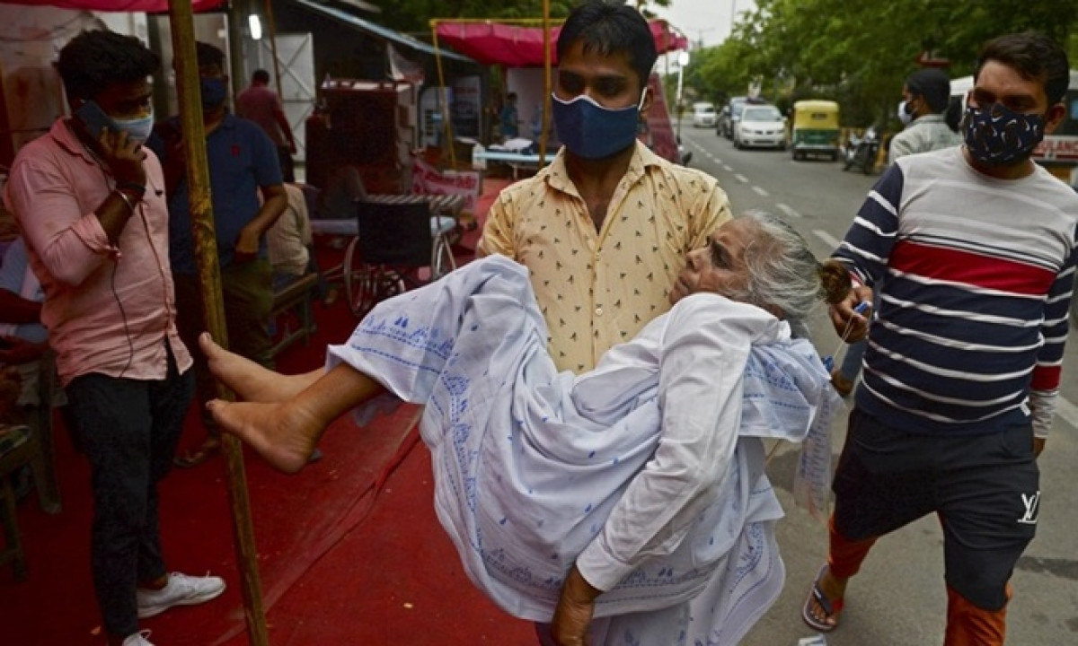Người thân đưa bệnh nhân Covid-19 bị khó thở đến trung tâm hỗ trợ oxy miễn phí ở ngoại ô New Delhi, Ấn Độ hôm 10/5. Ảnh: AFP.