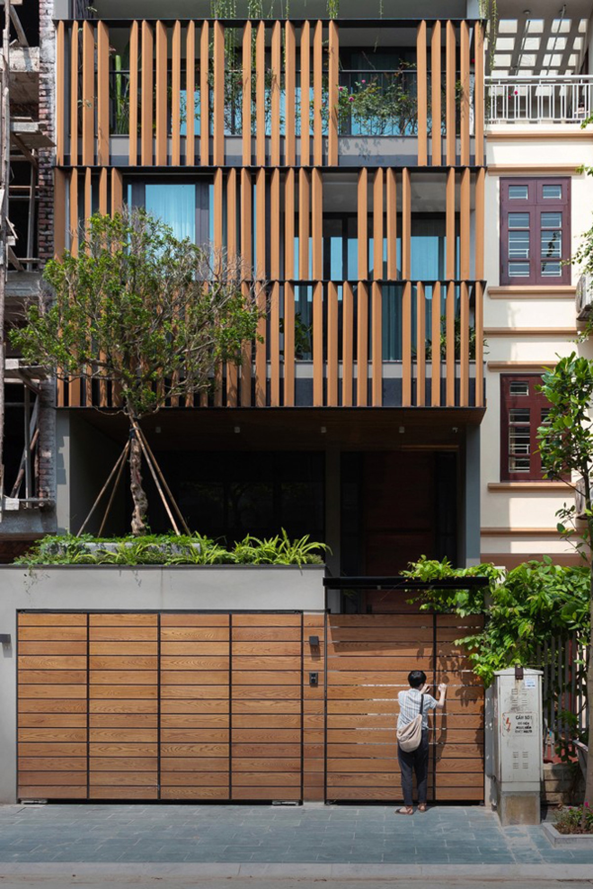 Công trình nằm ở quận Long Biên, Hà Nội, có cấu trúc của một ngôi nhà phố với hai mặt thoáng trước và sau. Các kiến trúc sư thiết kế đưa ra một hình ảnh ngôi nhà hiện đại mà vẫn gần gũi nhờ chất liệu gỗ ở hệ cổng và lam mặt tiền.