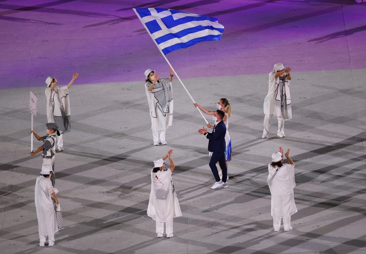 Hai VĐV Eleftherios Petrounias và Anna Korakaki của Hy Lạp cầm cờ tại lễ diễu hành. (Ảnh: Reuters).