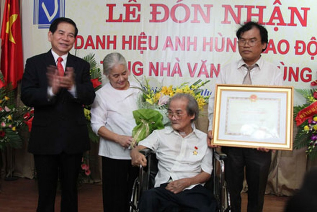 Chủ tịch nước Nguyễn Minh Triết đã trao tặng danh hiệu Anh hùng Lao động thời kỳ đổi mới cho nhà văn Sơn Tùng ngồi trên xe lăn.  (Ảnh: Nguyễn Đình Toán)