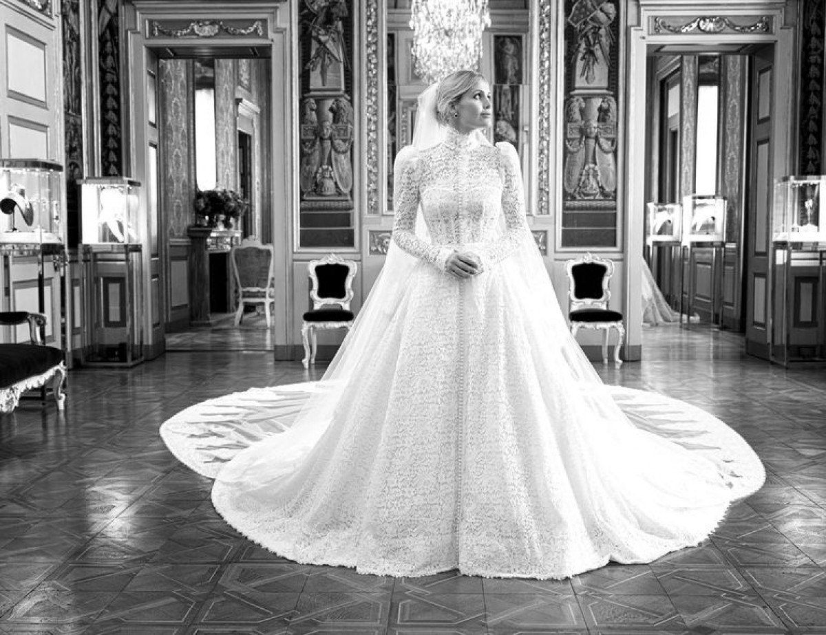 Chiếc váy cưới trắng, chất liệu ren lấy cảm hứng từ thời Victoria với thiết kế cầu vai và cổ cao đậm chất quý tộc.