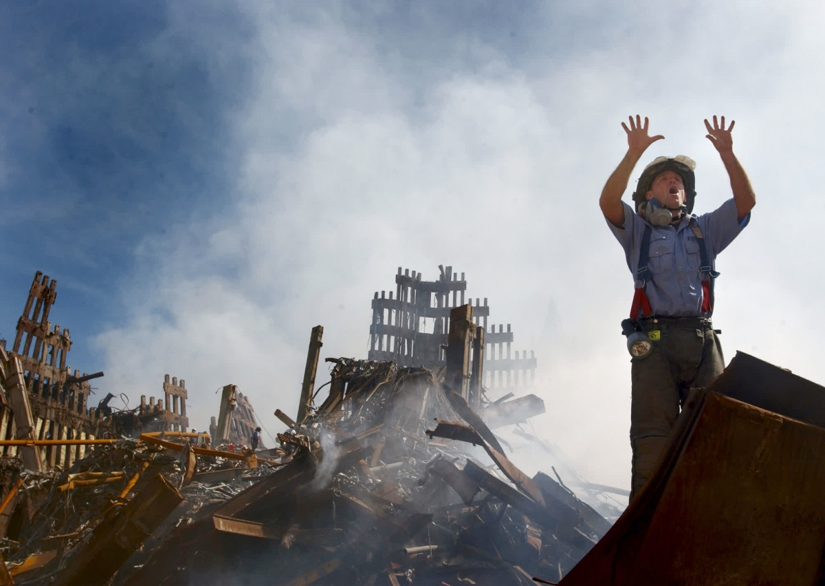 Một lính cứu hỏa thành phố New York đang gọi thêm các nhân viên khác khi làm việc tại đống đổ nát của WTC ngày 14/9/2001. Ảnh: Getty