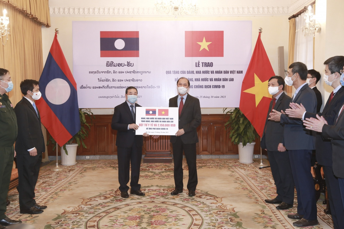 Thứ trưởng Ngoại giao Nguyễn Quốc Dũng trao tượng trưng vật tư y tế và số tiền 2.150.000 USD cho Đại sứ đặc mệnh Toàn quyền nước Cộng hòa Dân chủ Nhân dân Lào tại Việt Nam Sengphet Houngboungnuang.
