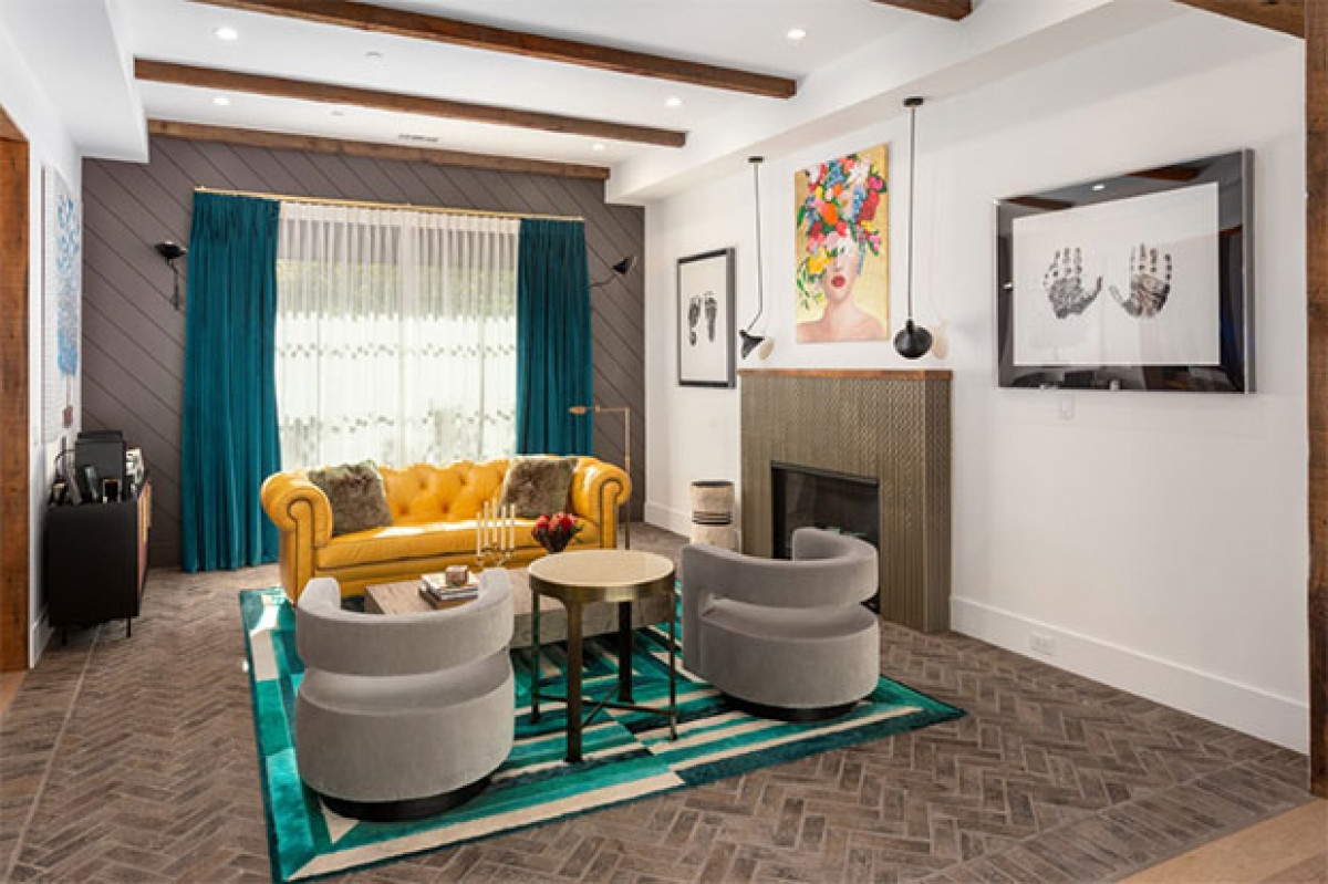 Phòng khách trang trọng nổi bật với màu sắc tươi sáng với ghế sofa màu vàng, vải dệt màu xanh mòng biển và được trang trí với những tác phẩm nghệ thuật đồ họa.