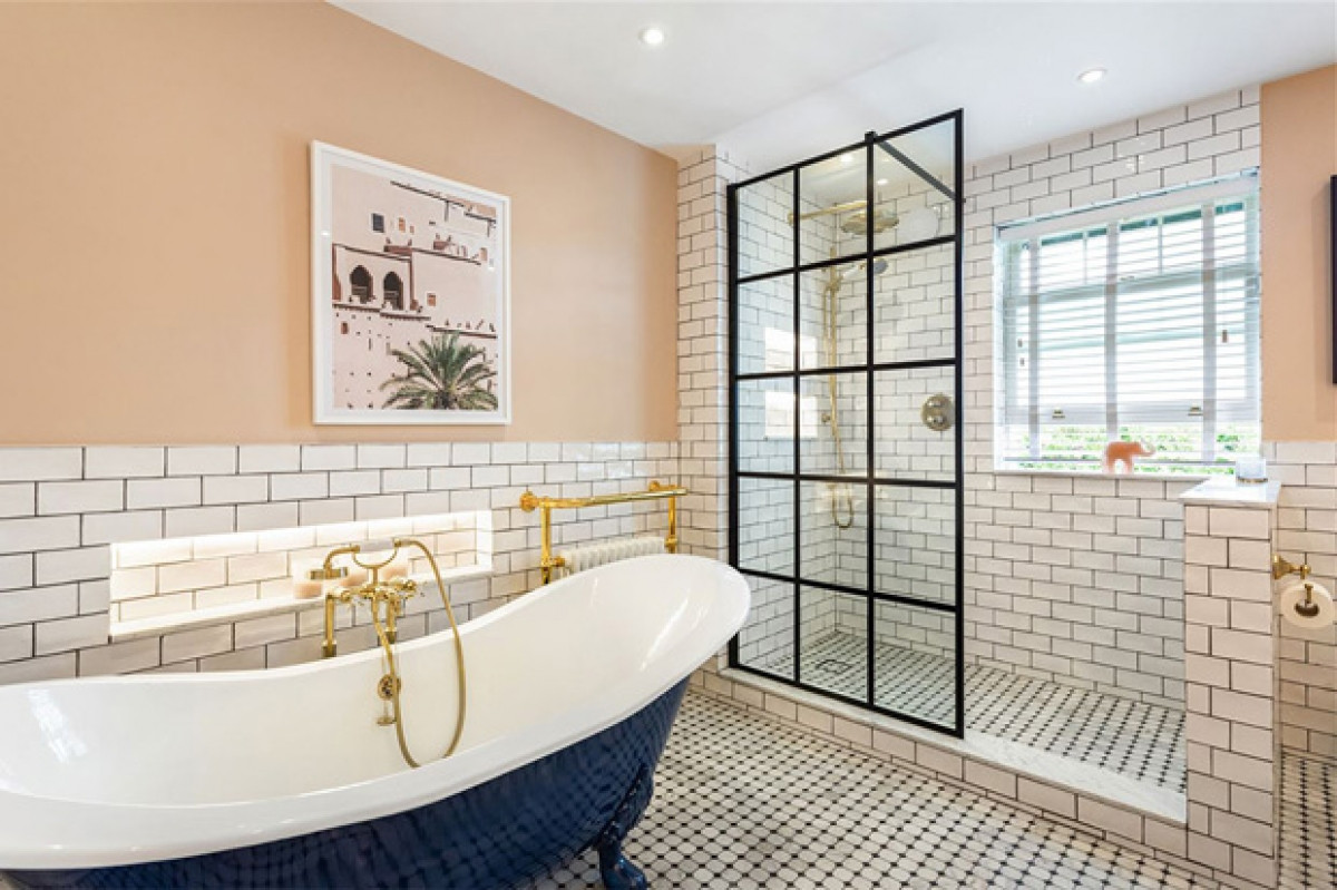 Màu hồng đào kết hợp gạch trắng với bồn tắm màu xanh nước biển tôn lên vẻ sang trọng cho phòng tắm.