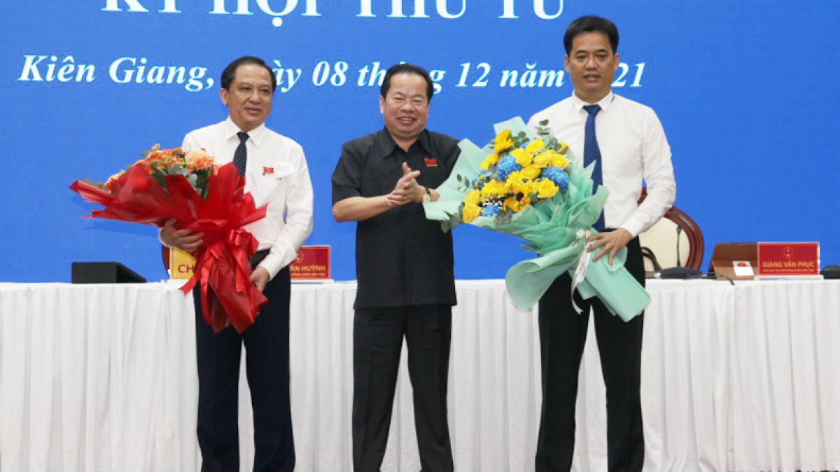 Ông Mai Văn Huỳnh - Chủ tịch HĐND tỉnh tặng hoa cho ông  Lê Quốc Anh (bên phải) và ông Nguyễn Đức Chính.