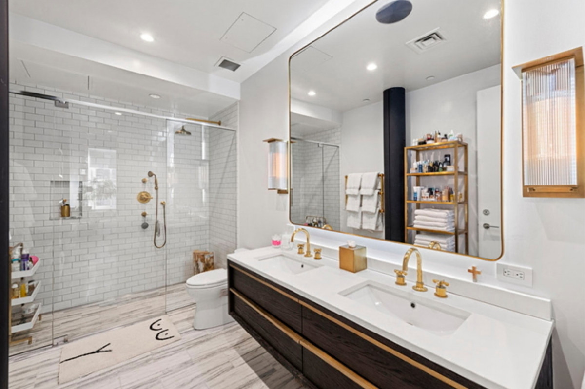 Phòng tắm với các đồ dùng thiết kế màu đồng trang nhã với gạch màu trắng mang phong cách rất New York.