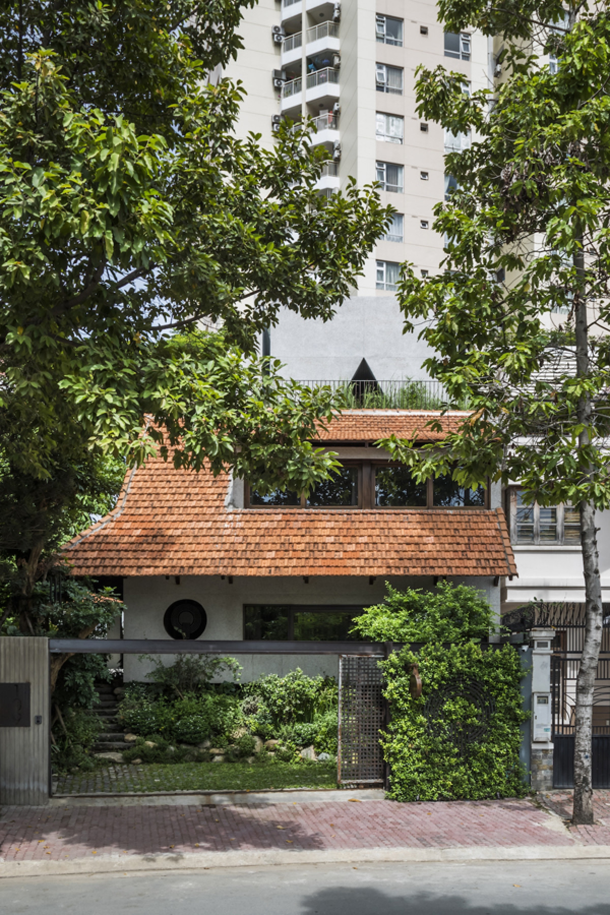 Công trình có tên là “Hiên quê”, được cải tạo từ một ngôi nhà cũ thành một không gian mới đa chức năng. Đây vừa là nhà ở gia đình, vừa là nơi sinh hoạt câu lạc bộ của những người ăn chay và thiền định. Ngôi nhà tọa lạc ở một khu đô thị mới thuộc quận 2, thành phố Hồ Chí Minh.