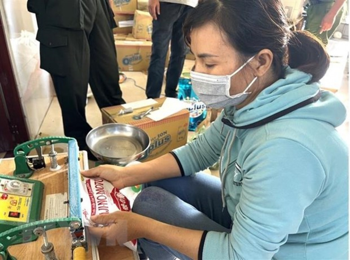 Bà Đinh Thị Đoan ở xã Sông Trầu Trảng Bom, tỉnh Đồng Nai đang thực hiện đóng gói giả nhãn hiệu bột ngọt Ajinomoto và hạt nêm hiệu Knorr. (Ảnh : TTXVN phát)
