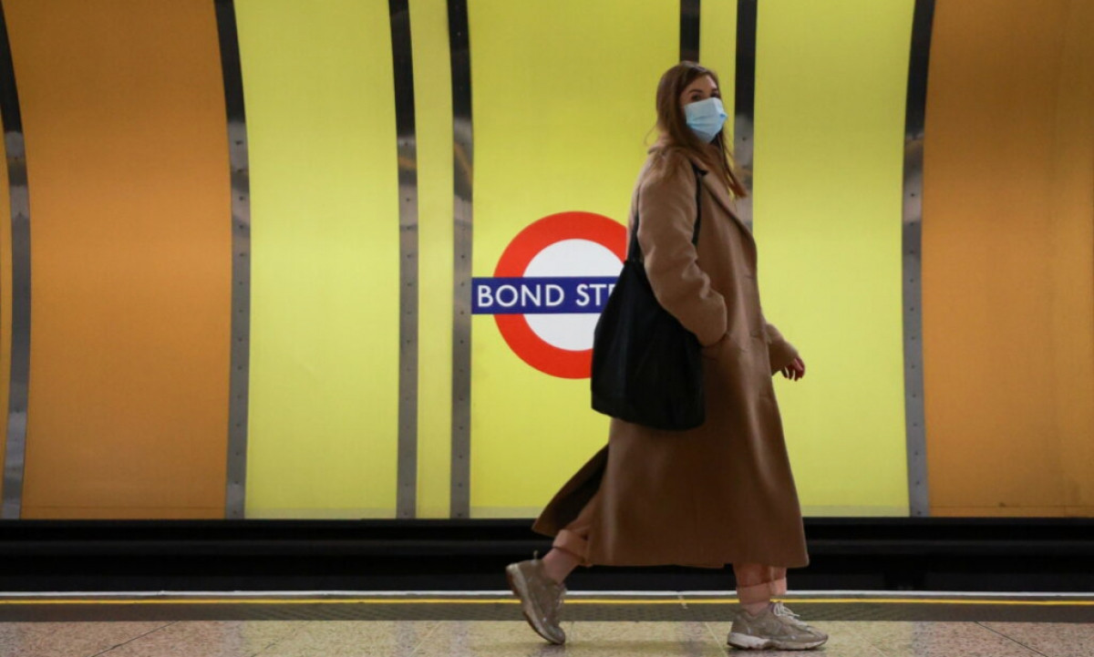 Người phụ nữ đeo khẩu trang tại ga tàu điện ngầm Bond Street ở London, Anh hôm 30/11/2021. Ảnh: Reuters