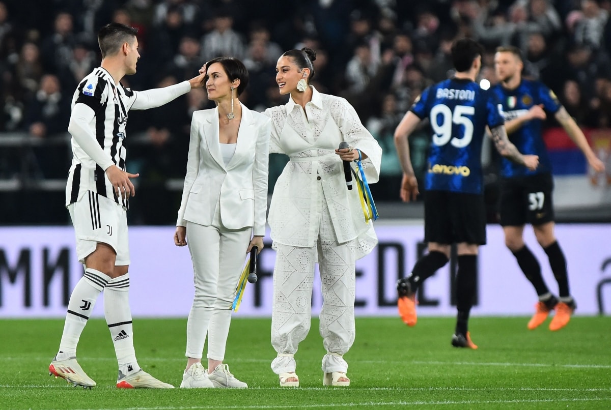 Hai ca sĩ nắm tay nhau thể hiện ca khúc huyền thoại Imagine của John Lennon trước trận Derby d'Italia trên sân vận động Allianz. (Ảnh: Reuters).