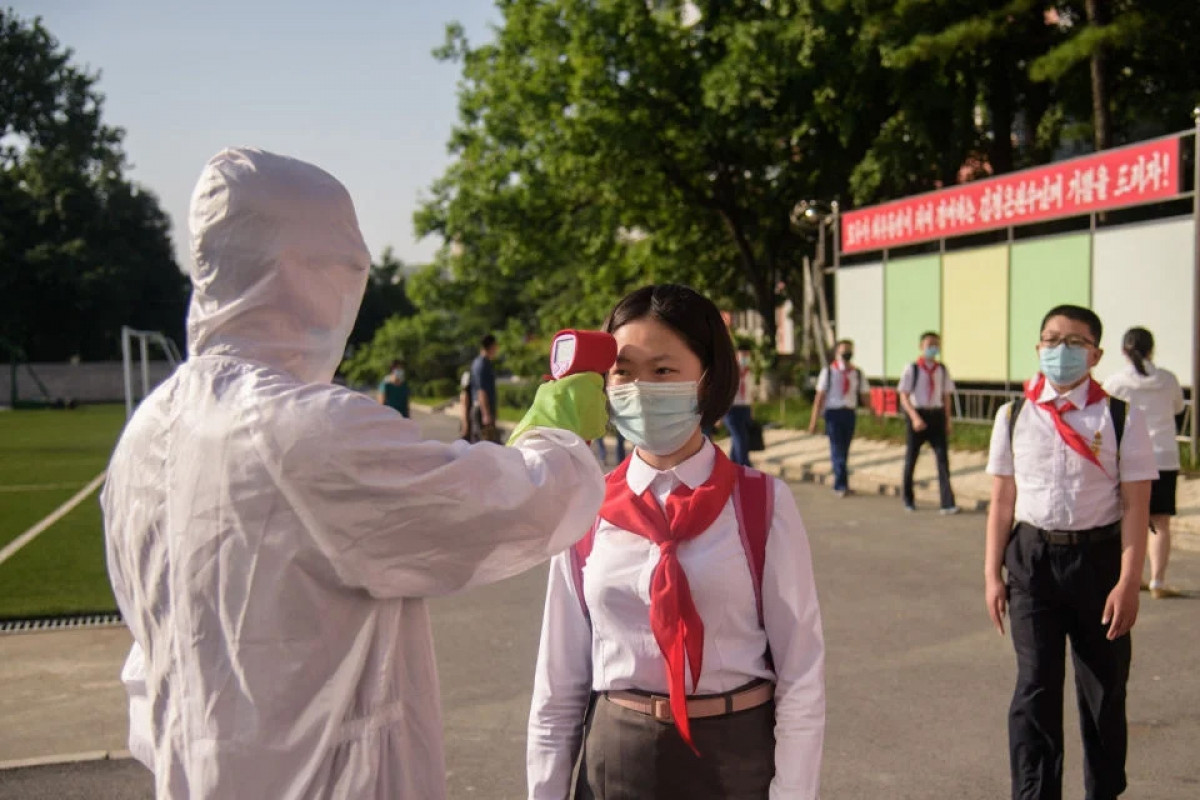 Học sinh đo thân nhiệt phòng dịch Covid-19 trước khi vao trường học ở Bình Nhưỡng, tháng 6/2021. Ảnh: Getty