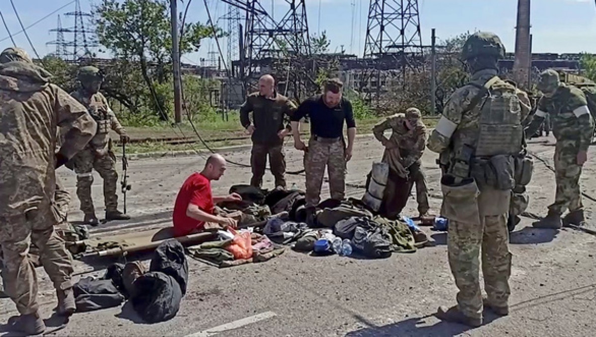 Một tay súng Ukraine cố thủ ở nhà máy thép Azovsta ra hàng ngày 18/5. Ảnh: Reuters