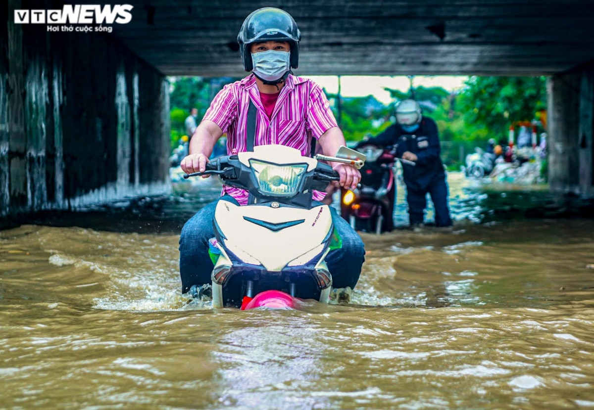 Nước ngập quá bánh xe nhưng người dân cố gắng vượt qua điểm ngập sâu ở hầm chui dân sinh qua Đại lộ Thăng Long.
