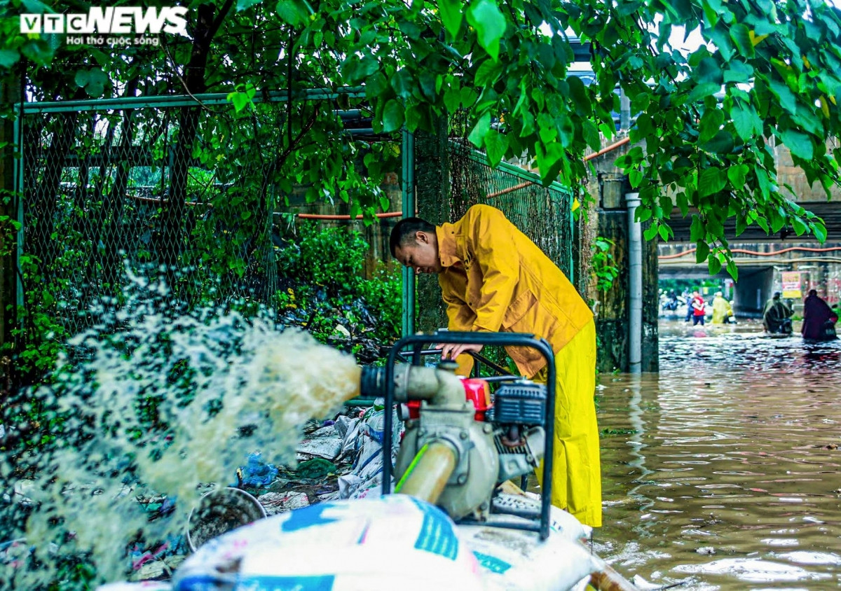Nhân viên Công ty Cấp thoát nước Hà Nội có mặt để cắm biển, dùng máy bơm để rút bớt nước.