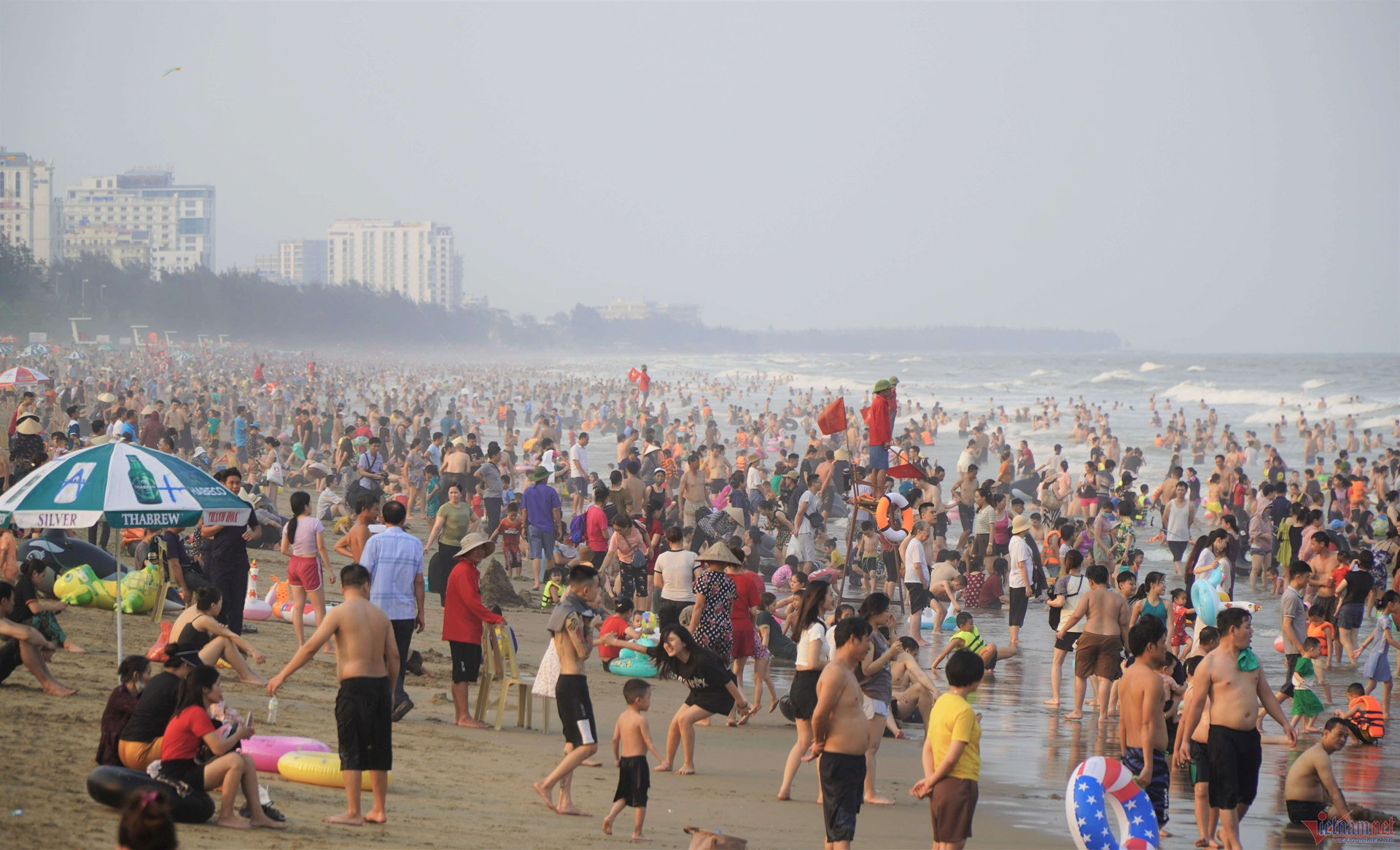 Nắng nóng gay gắt, người dân đổ xô xuống biển Sầm Sơn giải nhiệt - 1