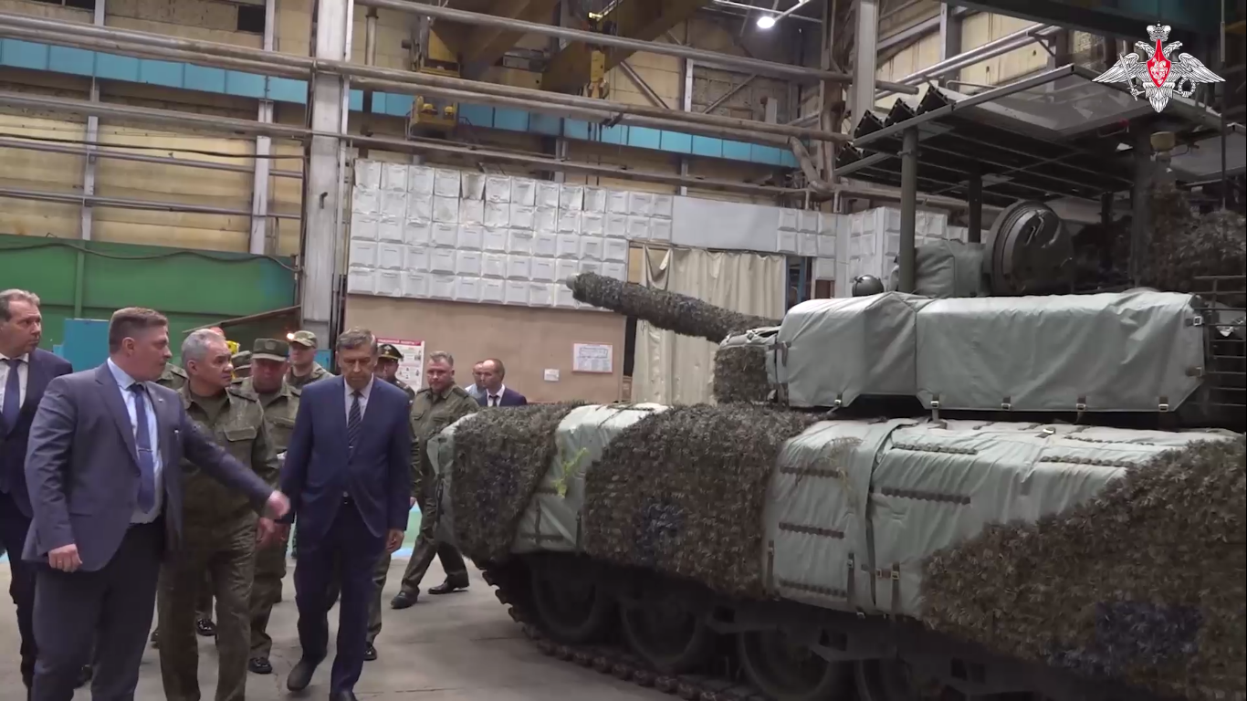 Bộ trưởng quốc phòng Nga Sergei Shoigu được giới thiệu hệ thống phòng vệ chủ động Krysha và lớp ngụy trang Nakidka trên xe tăng T-80BVM được sản xuất hàng loạt trong chuyến thăm đơn vị quốc phòng ở vùng Omsk thuộc Siberia hôm 17/6. (Ảnh: Bộ Quốc phòng Nga)