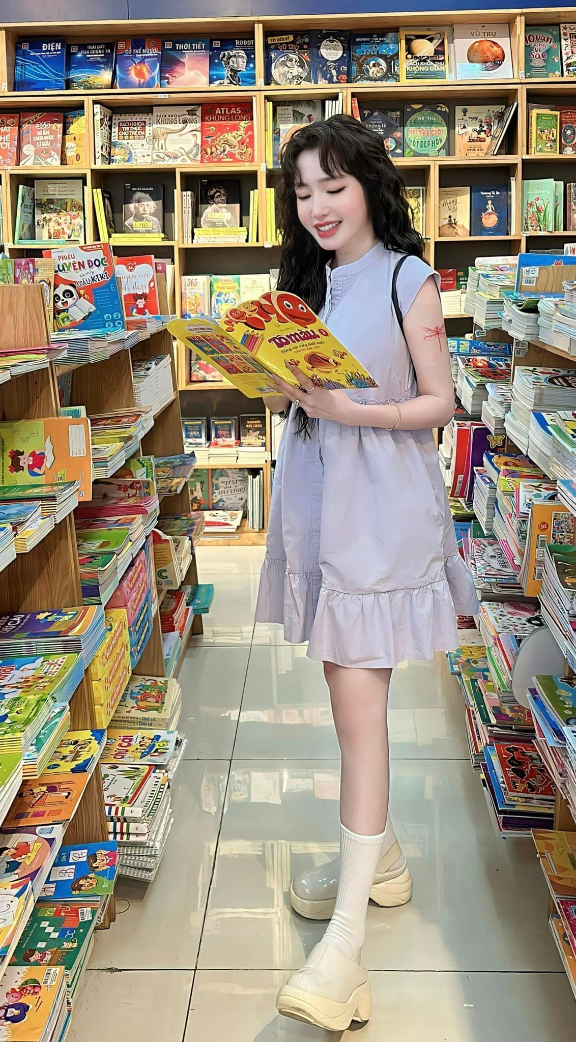 Elly Trần nhí nhảnh như học sinh khi chụp ảnh trong nhà sách.