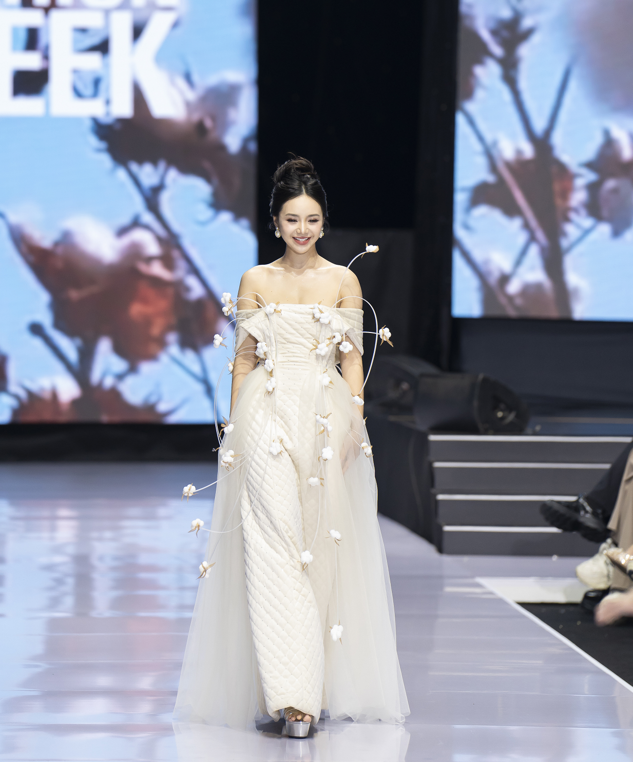Trên sàn catwalk, Quỳnh Kool tự tin trình diễn chiếc váy dài trắng bồng bềnh khoe bờ vai thon đầy cuốn hút.
