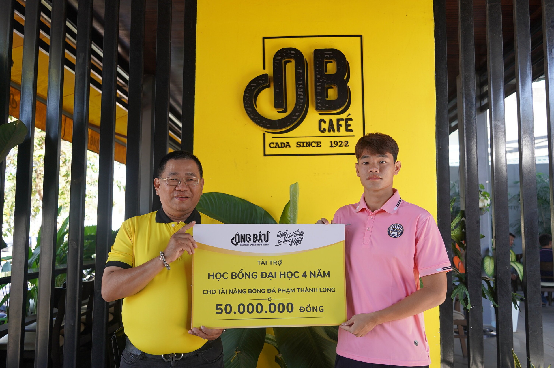 Tài năng bóng đá Phạm Thành Long nhận bảng tượng trưng học bổng từ đại diện Quỹ Phát triển Tài năng Việt của Ông Bầu.