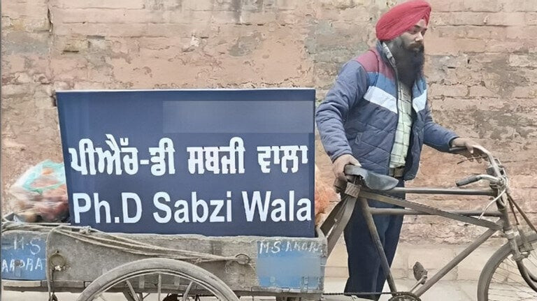 Ông Sandeep Singh bán rau trên xe đẩy của mình trên đường phố Punjab. Tấm bảng trên xe có ghi: 