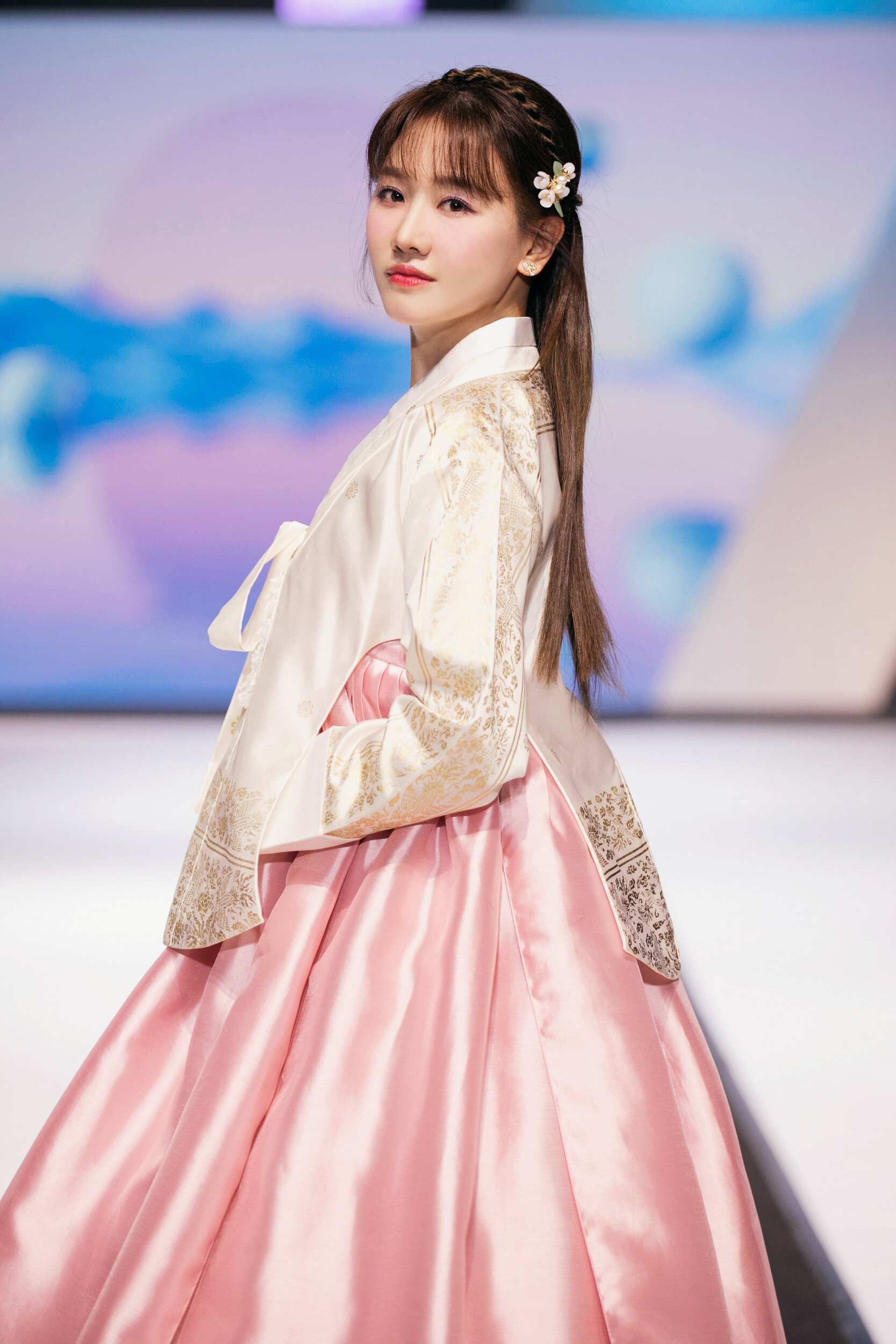 Hari Won xinh đẹp trong bộ hanbok truyền thống Hàn Quốc. Bộ trang phục được thiết kế tinh tế, pha trộn giữa phong cách cổ điển và vẻ hiện đại. Bà xã Trấn Thành từng trình diễn thời trang nhiều lần nên cô không còn bỡ ngỡ khi sải bước trên sàn diễn.