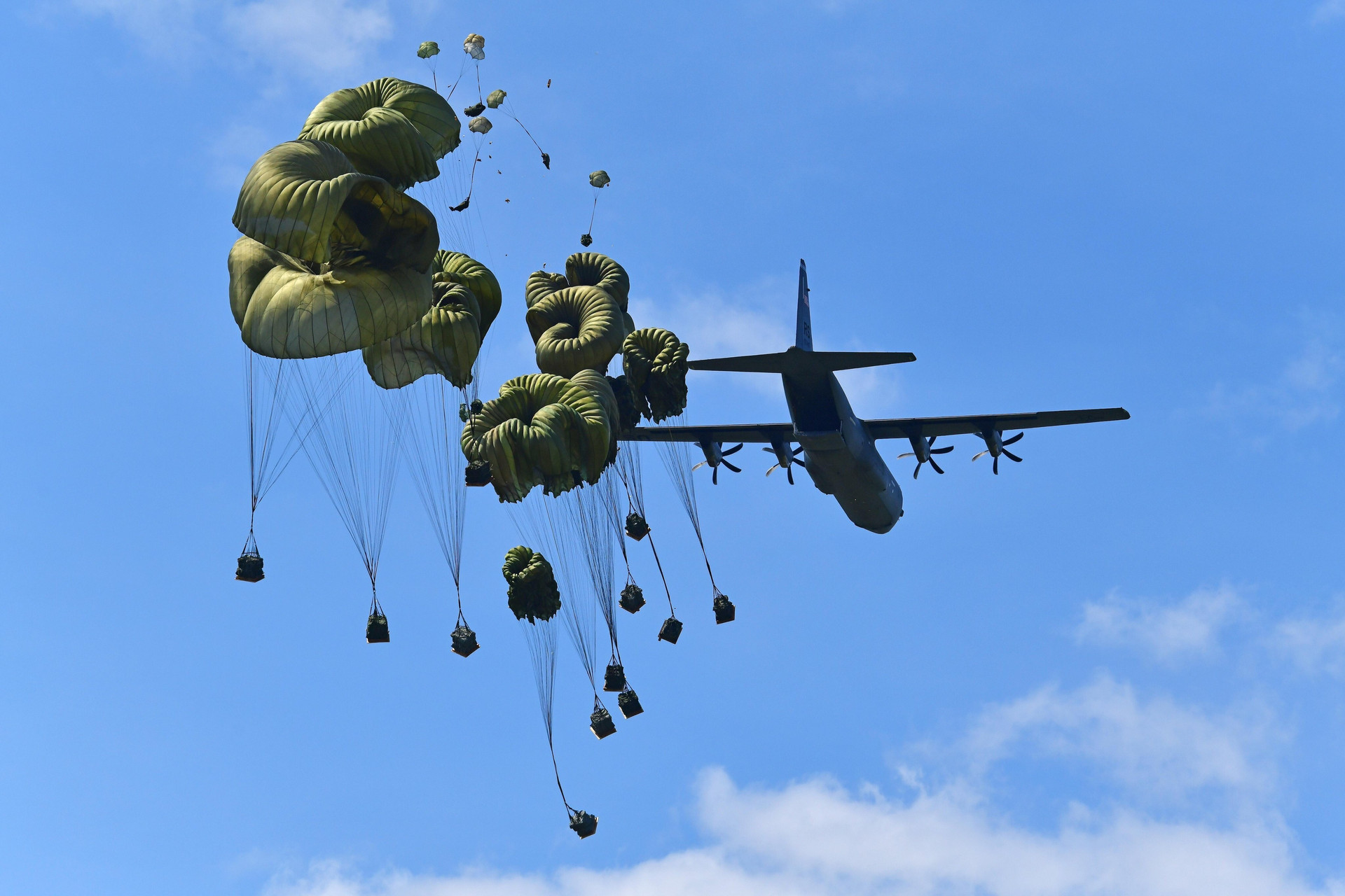 Lính nhảy dù Mỹ thả các gói hàng nặng từ máy bay C-130 Hercules xuống Khu thả quân Frida ở Pordenone, Italia.