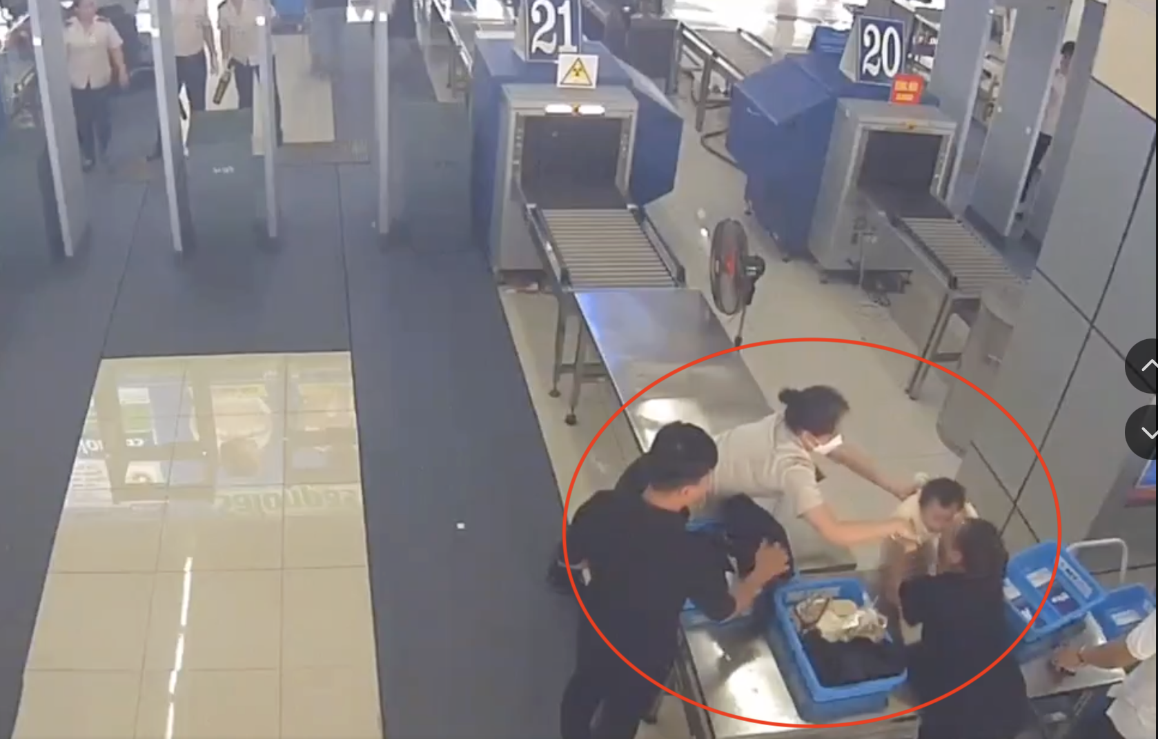 Nữ nhân viên an ninh sân bay kịp thời đỡ cháu bé ngã từ trên bàn. (Ảnh cắt từ clip)