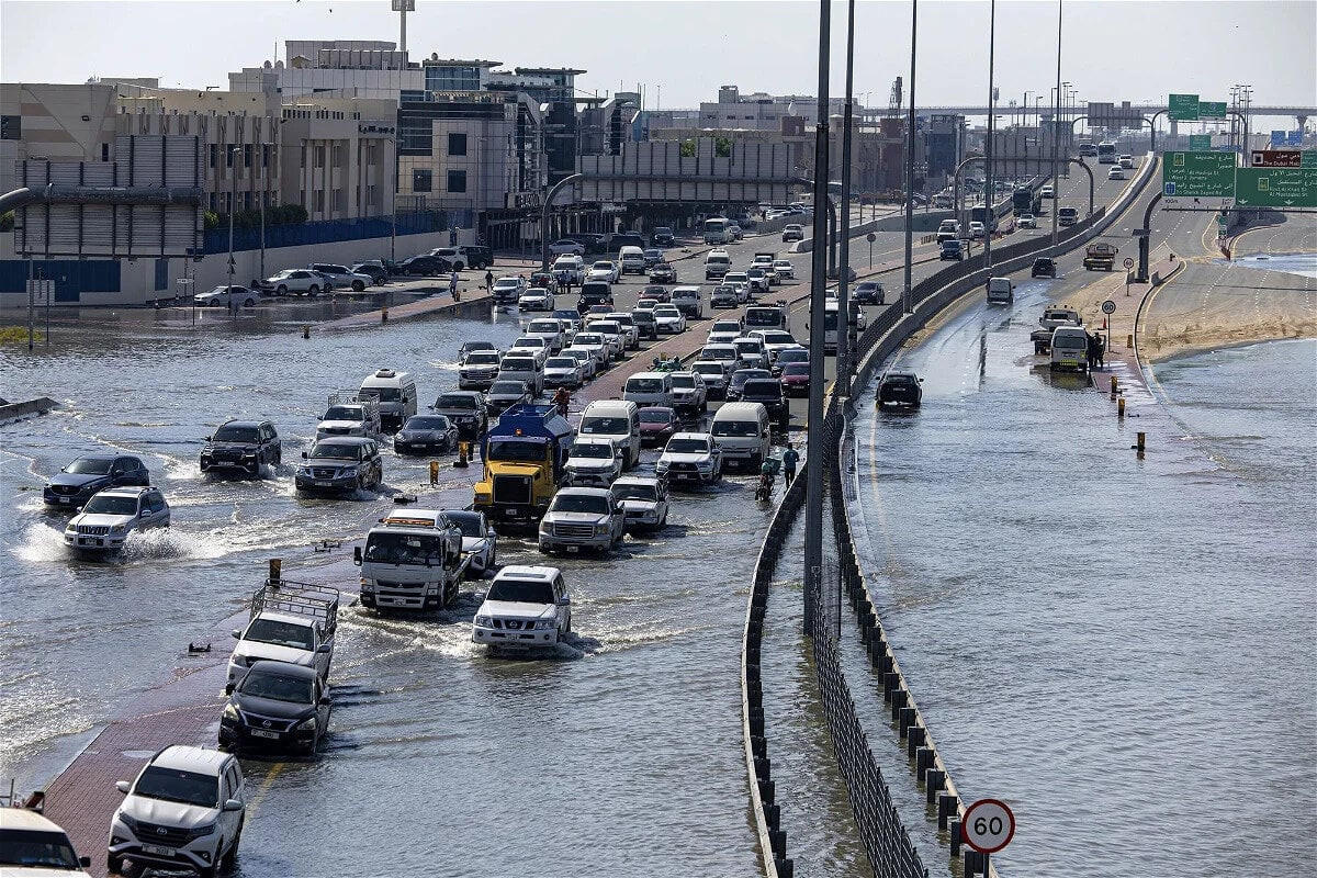 Các phương tiện di chuyển trên một tuyến đường còn ngập nước ở Dubai, UAE ngày 18/4. Ảnh: AP)