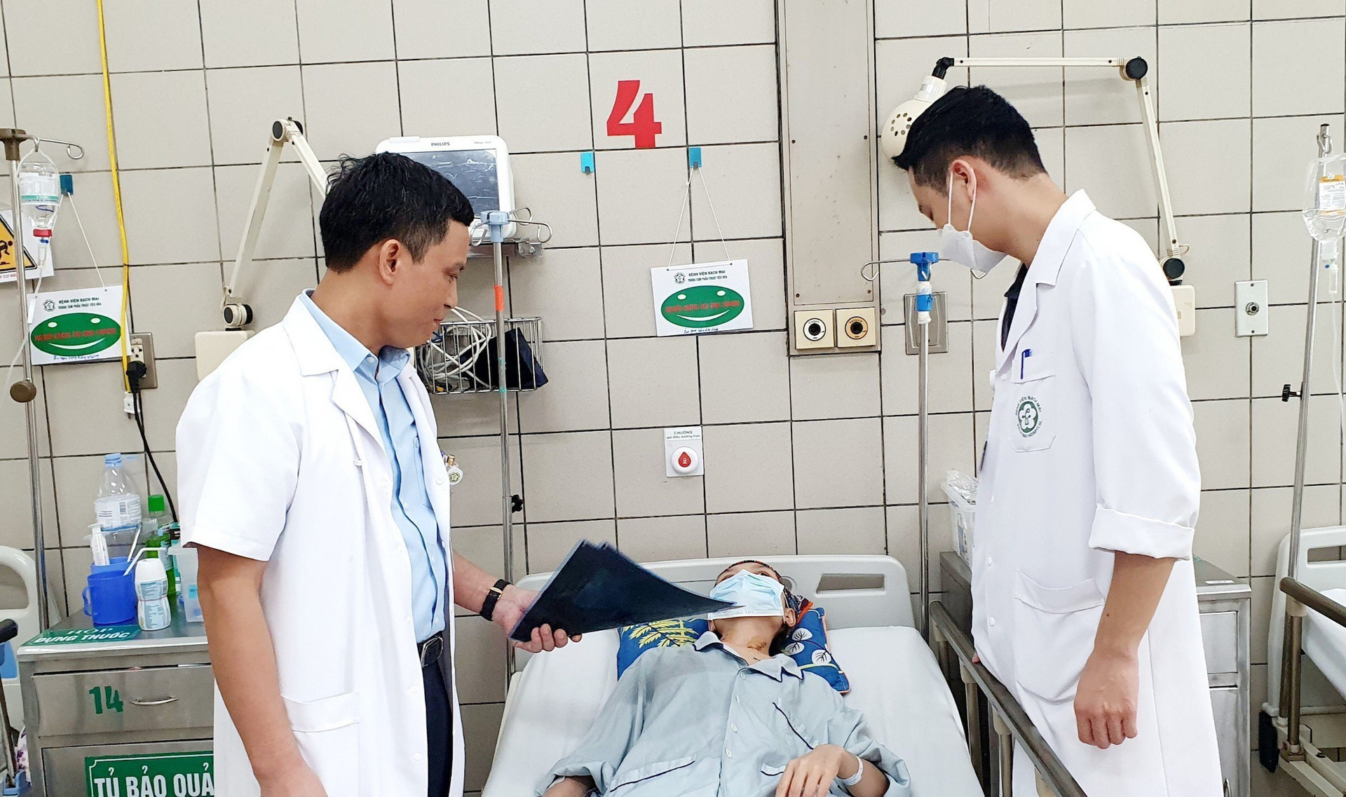 BS Hùng (bên trái) và BS Kiên (bên phải) thăm khám cho bệnh nhân trước khi được xuất viện.