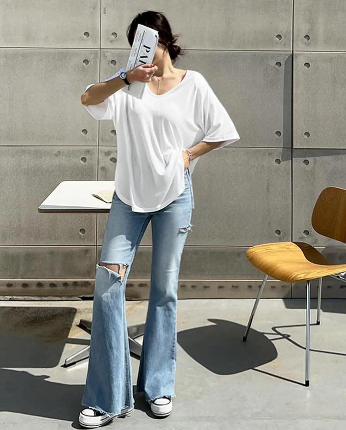 Quần jeans ống loe với áo thun trắng dáng thụng đem lại vẻ đẹp nữ tính, trẻ trung.