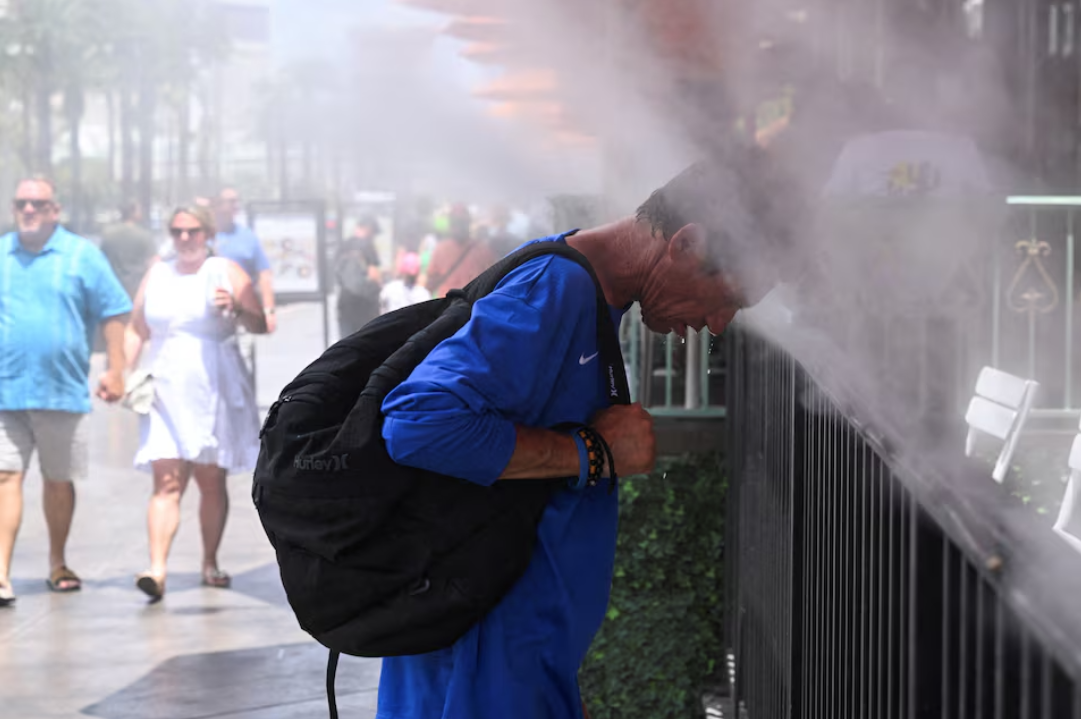 Người đàn ông xả nước giải nhiệt trong một đợt nắng nóng dữ dội ở châu Âu. (Ảnh: Reuters)