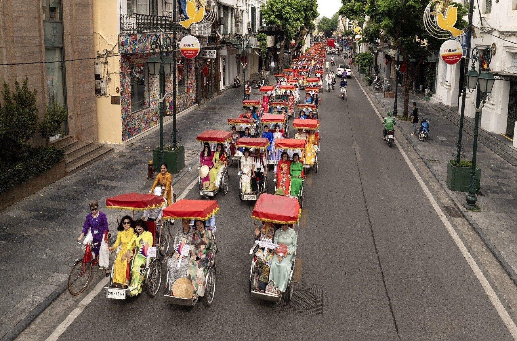 Các thành viên CLB Di sản áo dài Việt Nam thành phố Hà Nội đã có buổi diễu hành bằng xe đạp và xe xích lô quanh hồ Hoàn Kiếm.
