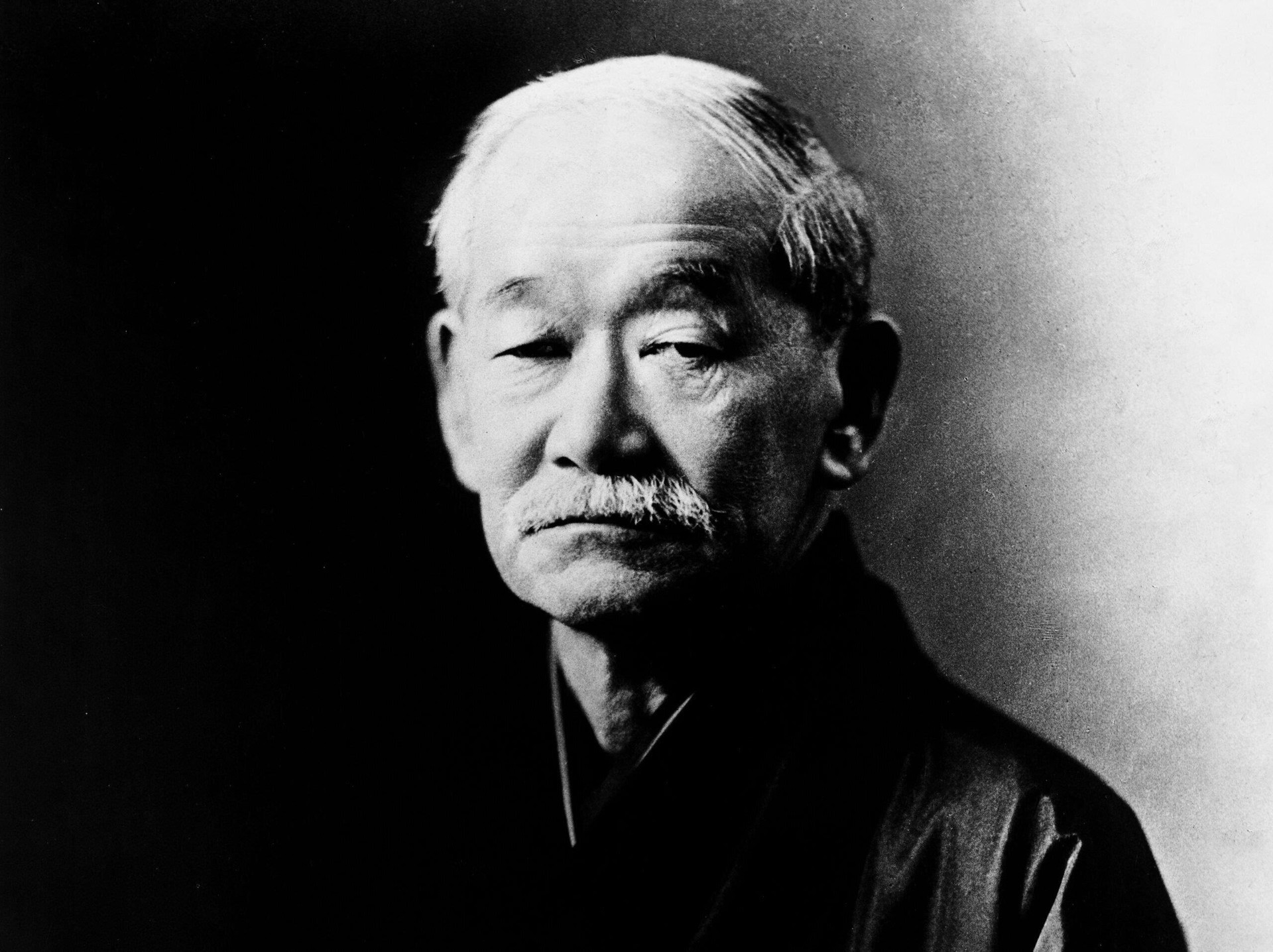 1.Kano Jigoro (sinh ngày 10/12/1860 – mất ngày 4/5/1938) là người sáng lập môn Judo. Judo là môn võ thuật đầu tiên của Nhật Bản được quốc tế công nhận. Judo cũng là môn võ đầu tiên trở thành môn thể thao thi đấu chính thức tại Olympic. Một trong những di sản lớn nhất của Kano là việc ông áp dụng đồng phục luyện tập, hệ thống thăng cấp, xếp hạng (Kyu/Dan), hệ thống đai (đai trắng đến đai đen) và phát triển các phương pháp giảng dạy có hệ thống hóa. Nhiều võ sĩ Judo sau đó đã đi khắp thế giới để truyền bá môn võ này, trong đó có Mitsuyo Maeda, người đã sang Brazil và truyền dạy kỹ thuật cho gia đình Gracie, dẫn đến sự ra đời của Jiu-Jitsu Brazil cũng như sự ra đời của võ tổng hợp. Khi hầu hết các môn võ thuật đã tách ra thành nhiều hướng khác nhau, Judo vẫn giữ nguyên bản chất trong suốt hơn 100 năm qua. Vì lý do đó, Jigoro Kano là là võ sĩ có ảnh hưởng nhất trong 100 năm qua.