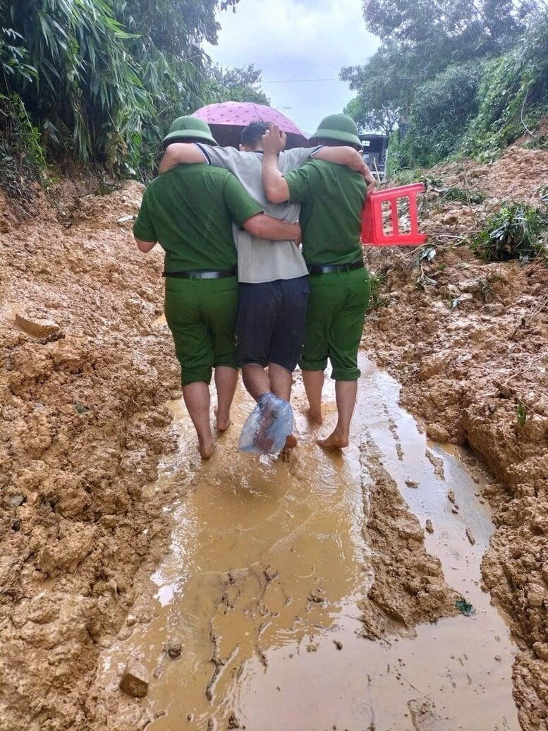 Với đôi chân trần, các chiến sỹ công an đưa người dân gặp nạn ra nơi an toàn. (Ảnh: VGP/NN)