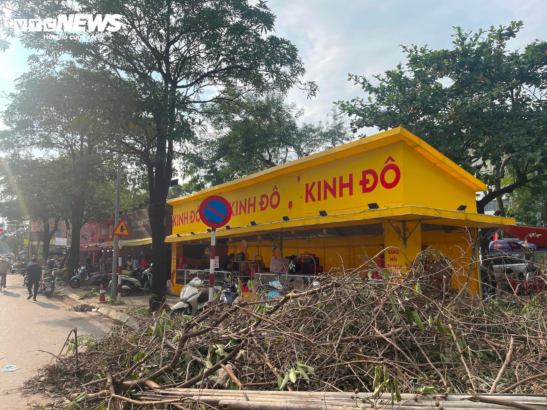 Trước một quầy bánh trung thu Kinh Đô, cành cây rơi rụng do ảnh hưởng của bão Yagi vẫn chưa kịp dọn dẹp.