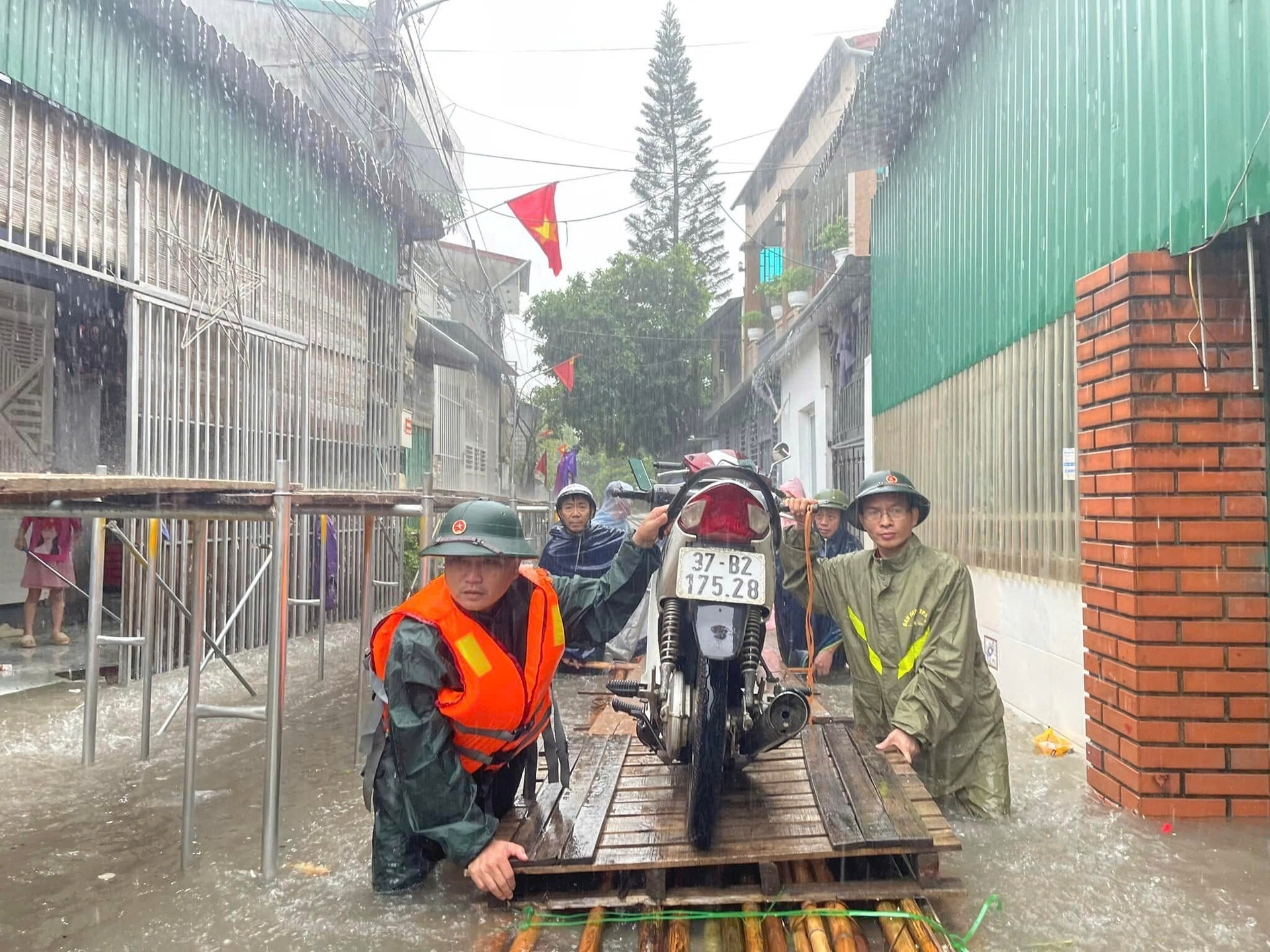 Lực lượng chức năng giúp người dân di chuyển đồ tại nơi ngập phường Hồng Sơn.