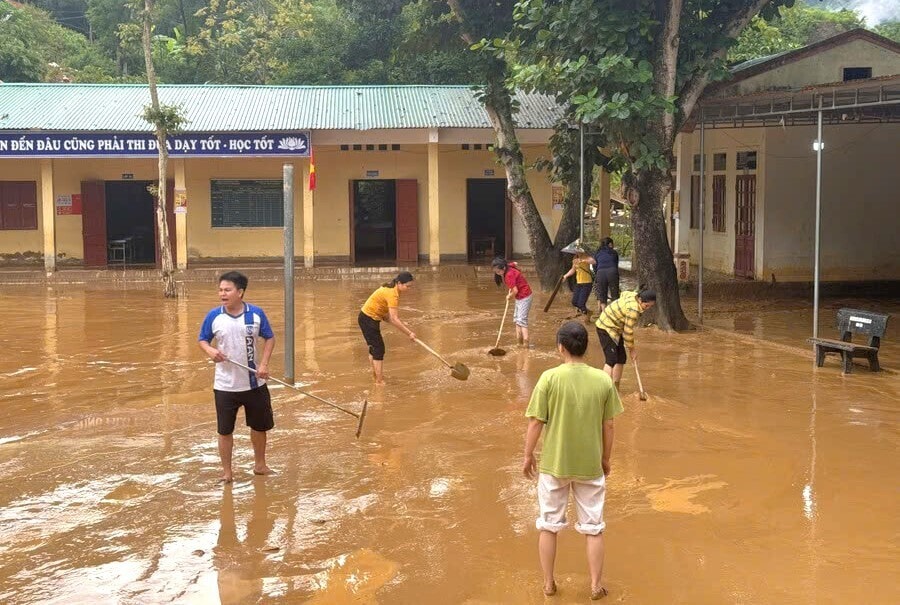 Các thầy cô dọn dẹp vệ sinh bùn đất sau trận lũ ống